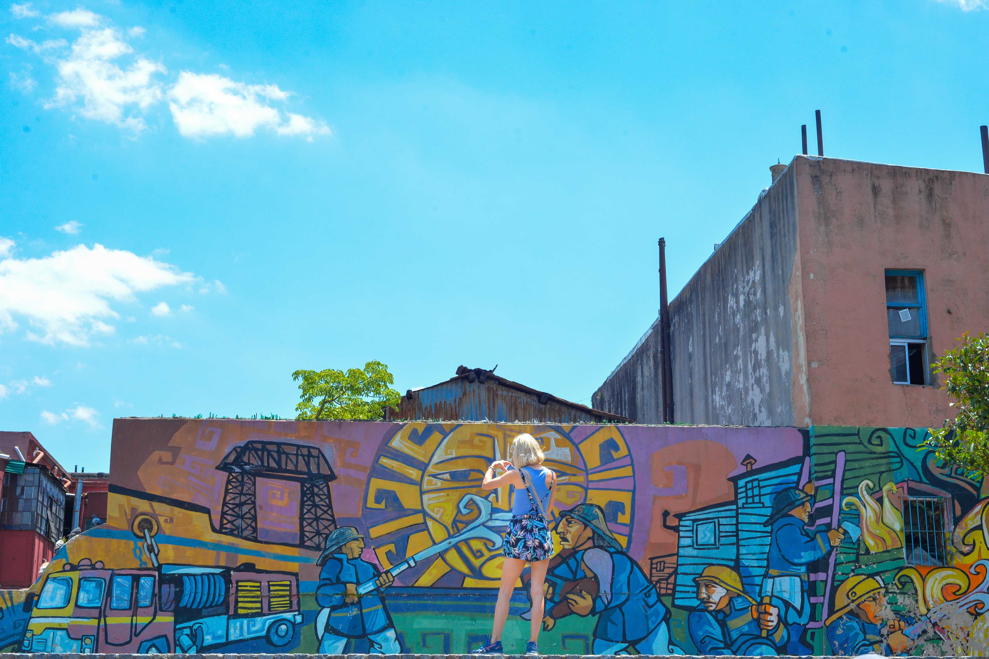 Woman stands in front of colorful wall in Buenos Aires