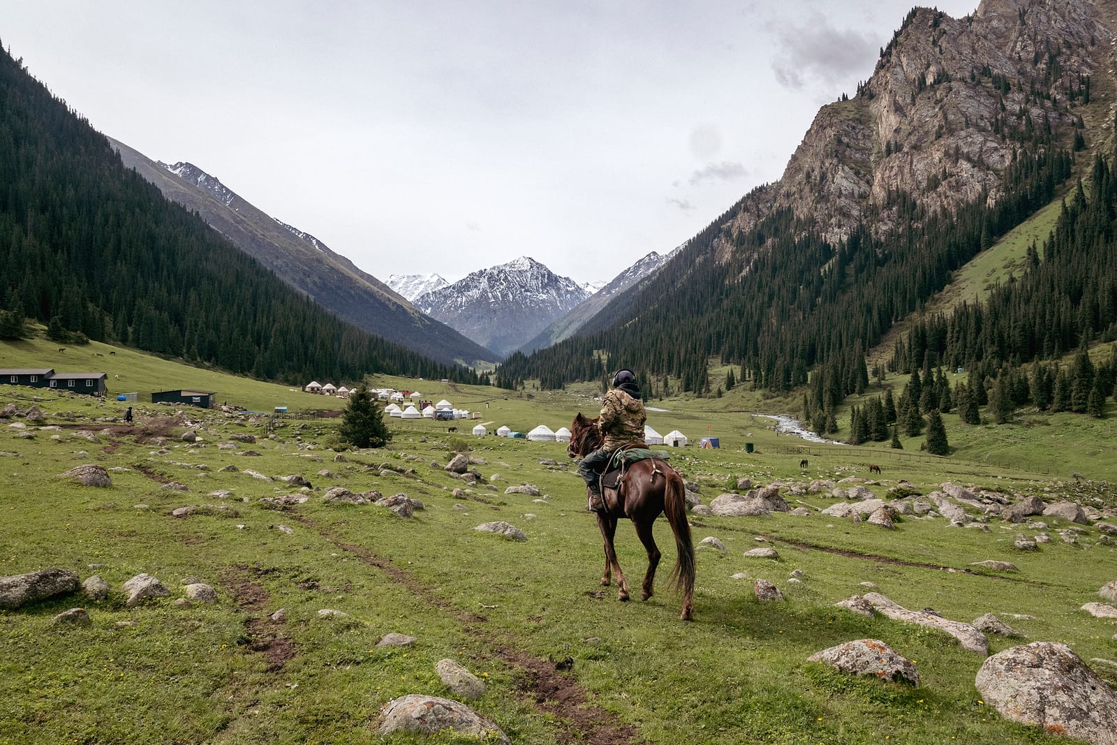 A rider crossing the meadow below the pass